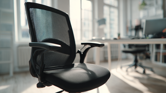 Black ergonomic office chair with mesh backrest placed in a bright modern workspace, showing adjustable armrests and clean professional design